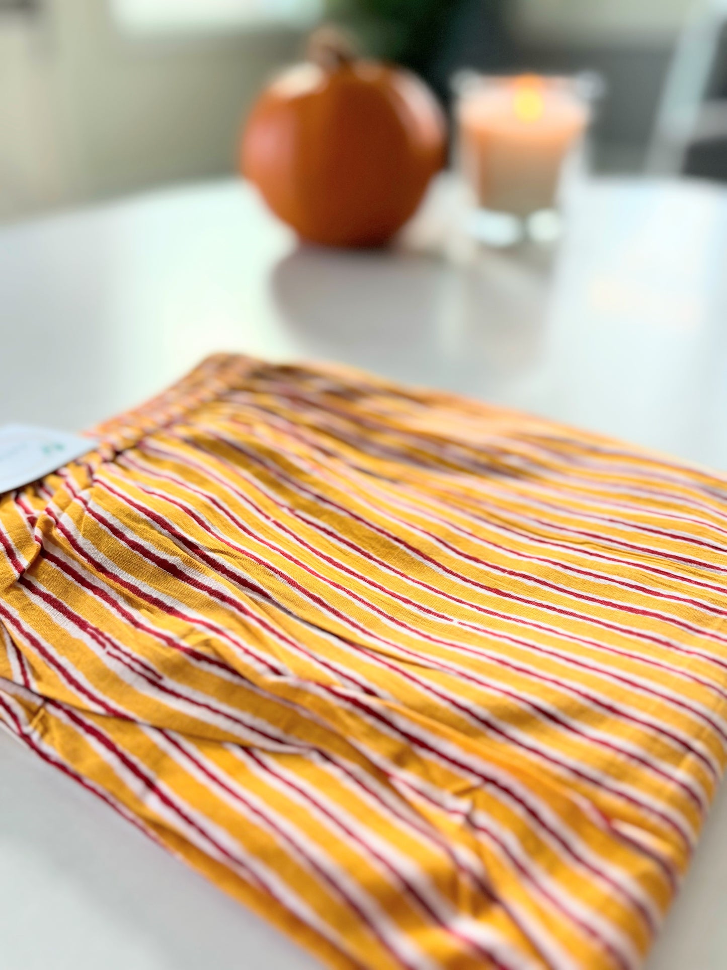 Relaxing cotton pajama pants for women with a colorful yellow and red striped print, elastic waist, and practical pockets