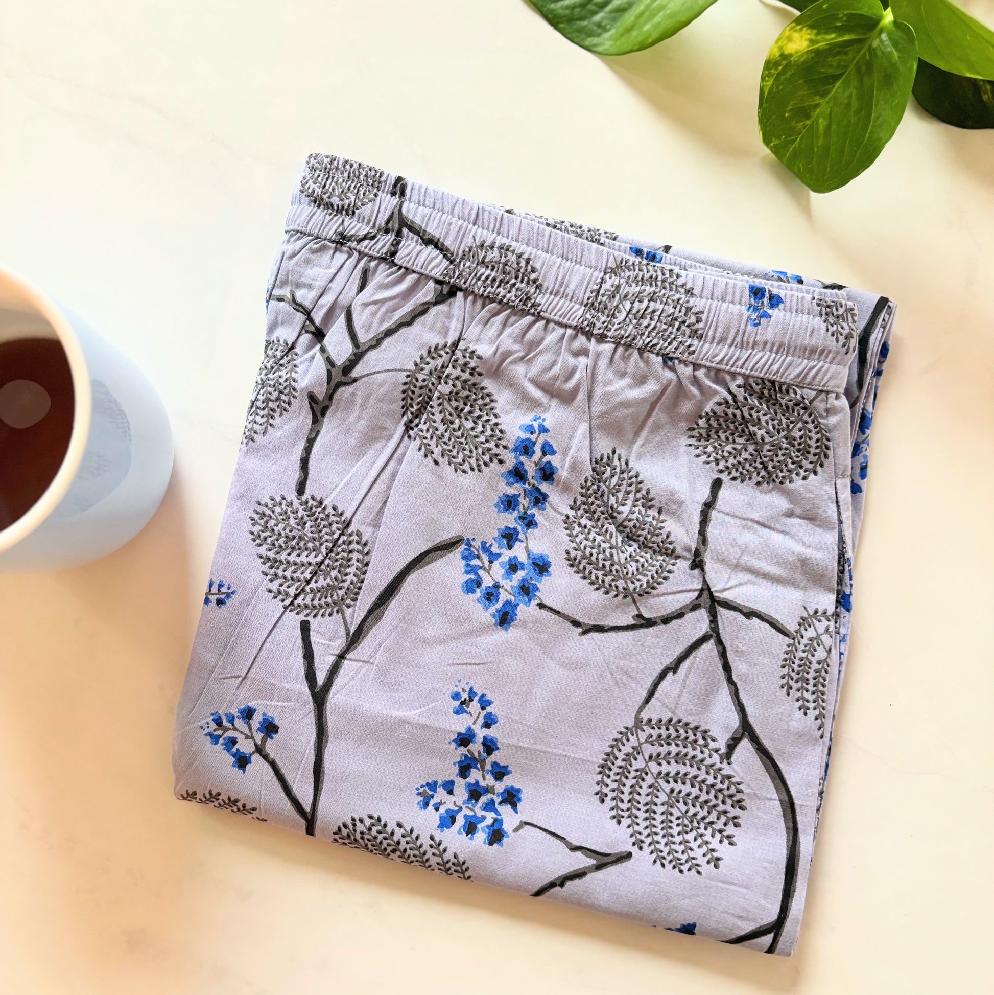 Modern cotton lounge pants with dark blue and black flowers on a light violet-blue fabric, perfect for relaxation or casual wear.