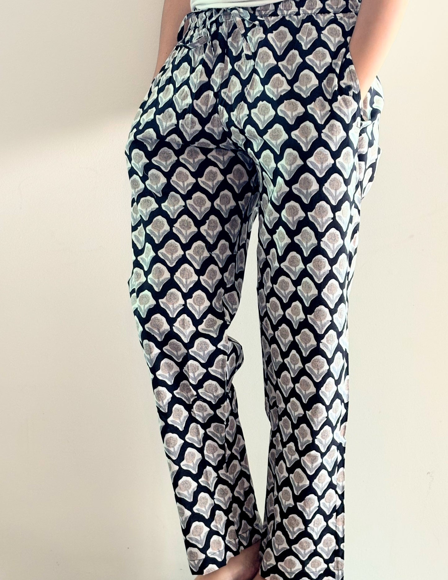 Tropical cotton pajama pants for women with a floral print, featuring a relaxed fit, elastic waistband, and drawstring tie.