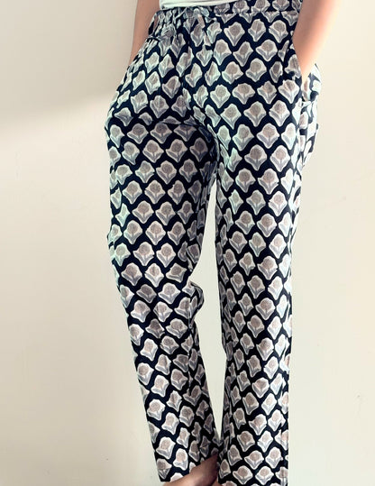 Tropical cotton pajama pants for women with a floral print, featuring a relaxed fit, elastic waistband, and drawstring tie.
