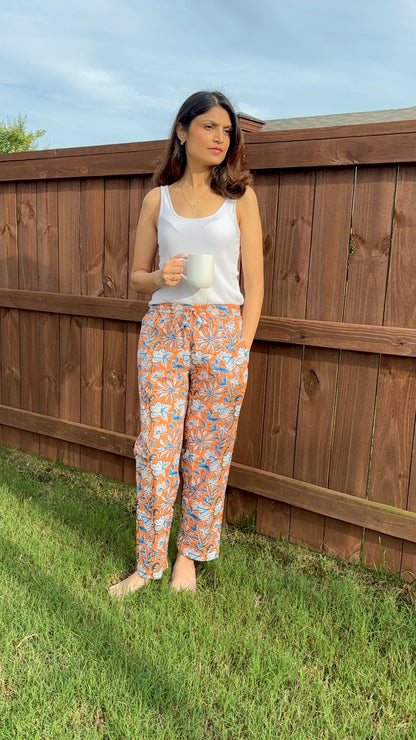 Soft, lightweight sleepwear for women, featuring pajama bottoms with an orange floral design on green, perfect for unwinding or sleeping.