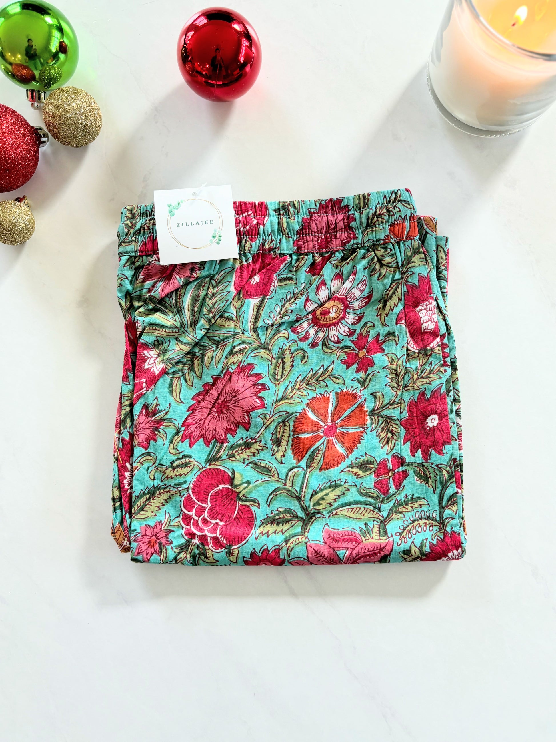 Floral print sleep pants for women with pink flowers on a green background, designed for comfort with an elastic waist and breathable cotton fabric.