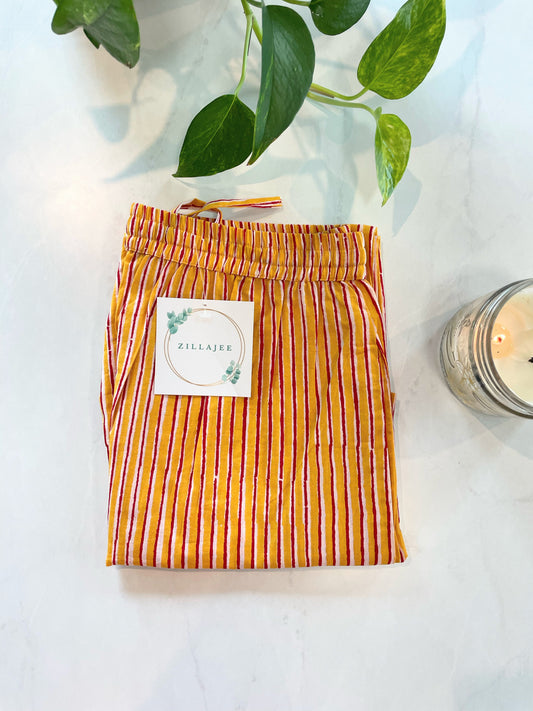 Women's 100% cotton pajama pants with yellow and red stripes, featuring an elastic waistband and side pockets.
