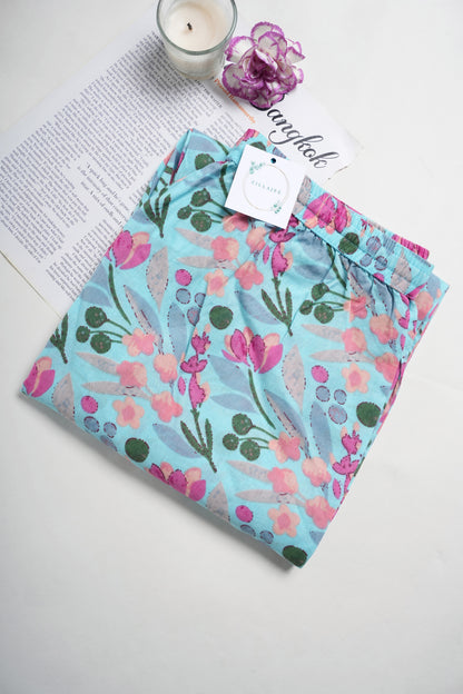 Chic handmade blue cotton lounge pants with pink floral print, practical side pockets, and a drawstring waistband — stylish and breathable for bridal gifts or everyday comfort.