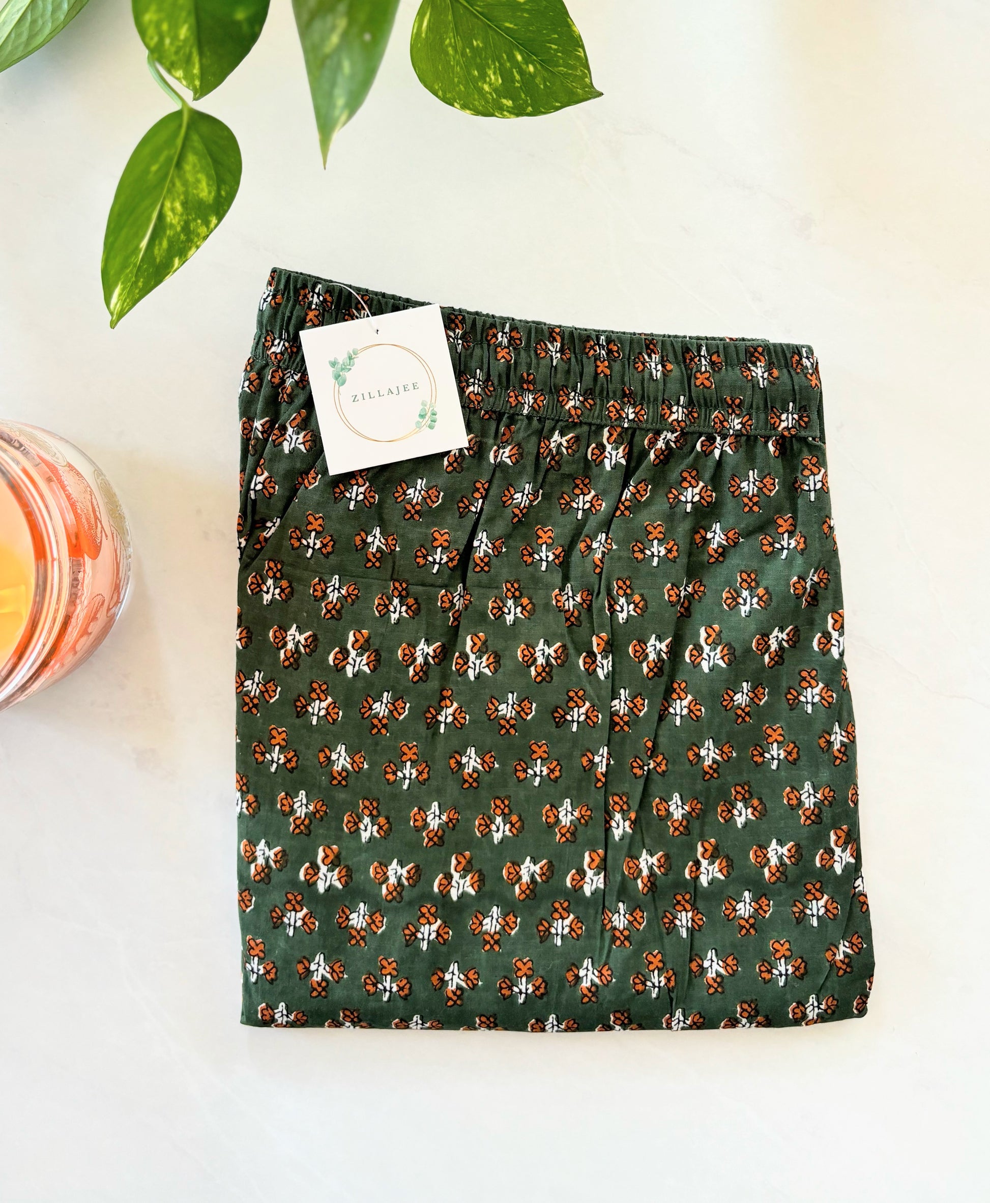 Ladies’ pajama bottoms in soft cotton with a vibrant orange floral pattern on green, designed for cooling, comfort, and easy lounging.