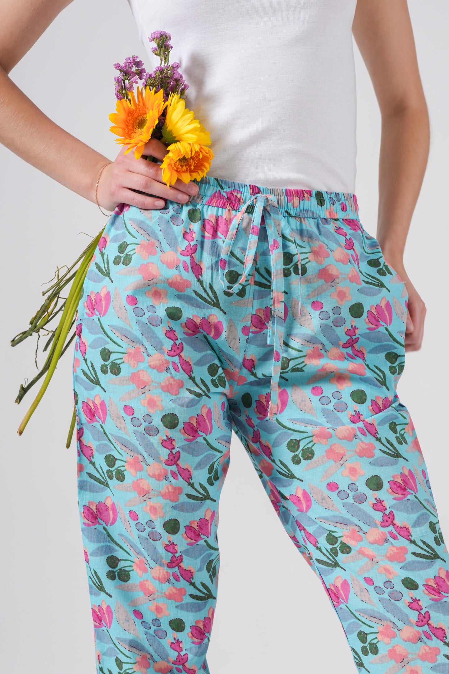 Women's pajama pants in 100% cotton with a pink flower pattern on blue, elastic waist and pockets included — a thoughtful gift for book lovers or bridal party getting ready looks.