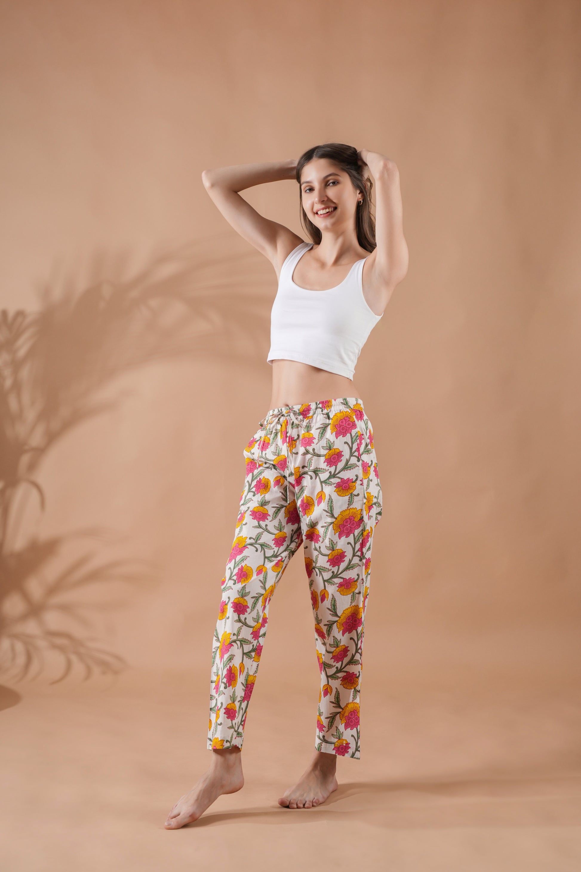 White cotton sleep pants for women with elastic waistband and bold pink-yellow floral print — trendy gift idea for a second wedding anniversary.