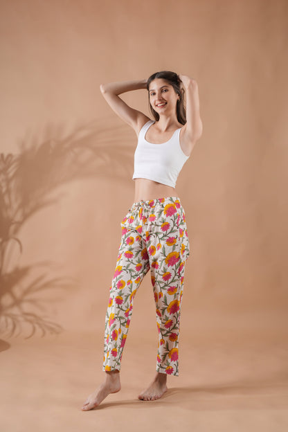 White cotton sleep pants for women with elastic waistband and bold pink-yellow floral print — trendy gift idea for a second wedding anniversary.
