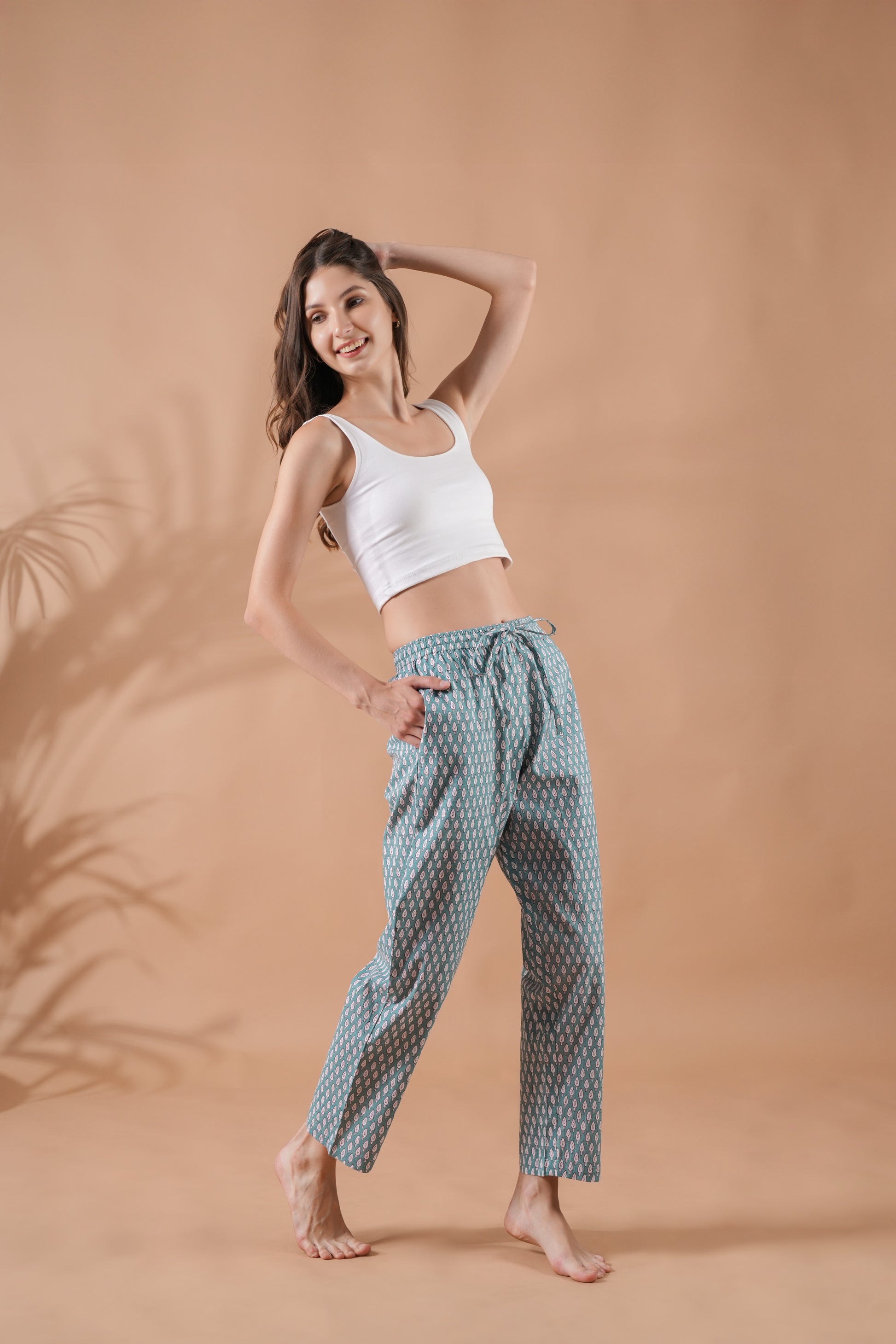 Handcrafted-style women’s jammies made from green cotton with red botanical prints, complete with elastic waistband and deep pockets—lightweight and stylish, great for gifts for flower lovers or relaxed reading nights.
