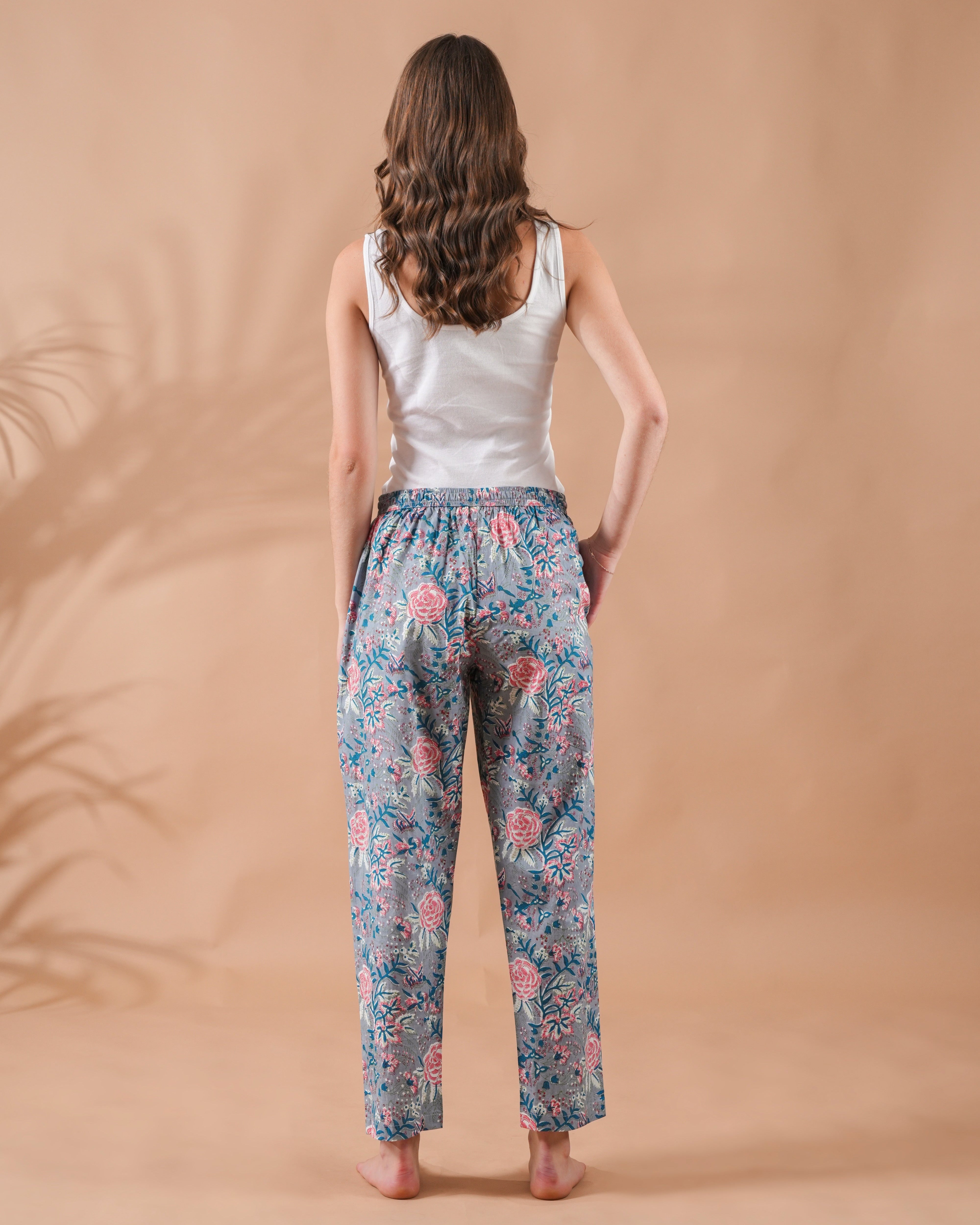Lightweight cotton sleep pants with pink floral design on gray, featuring an elastic waist and pockets—boho-style jammies perfect as cotton gift ideas or bridal party wear.