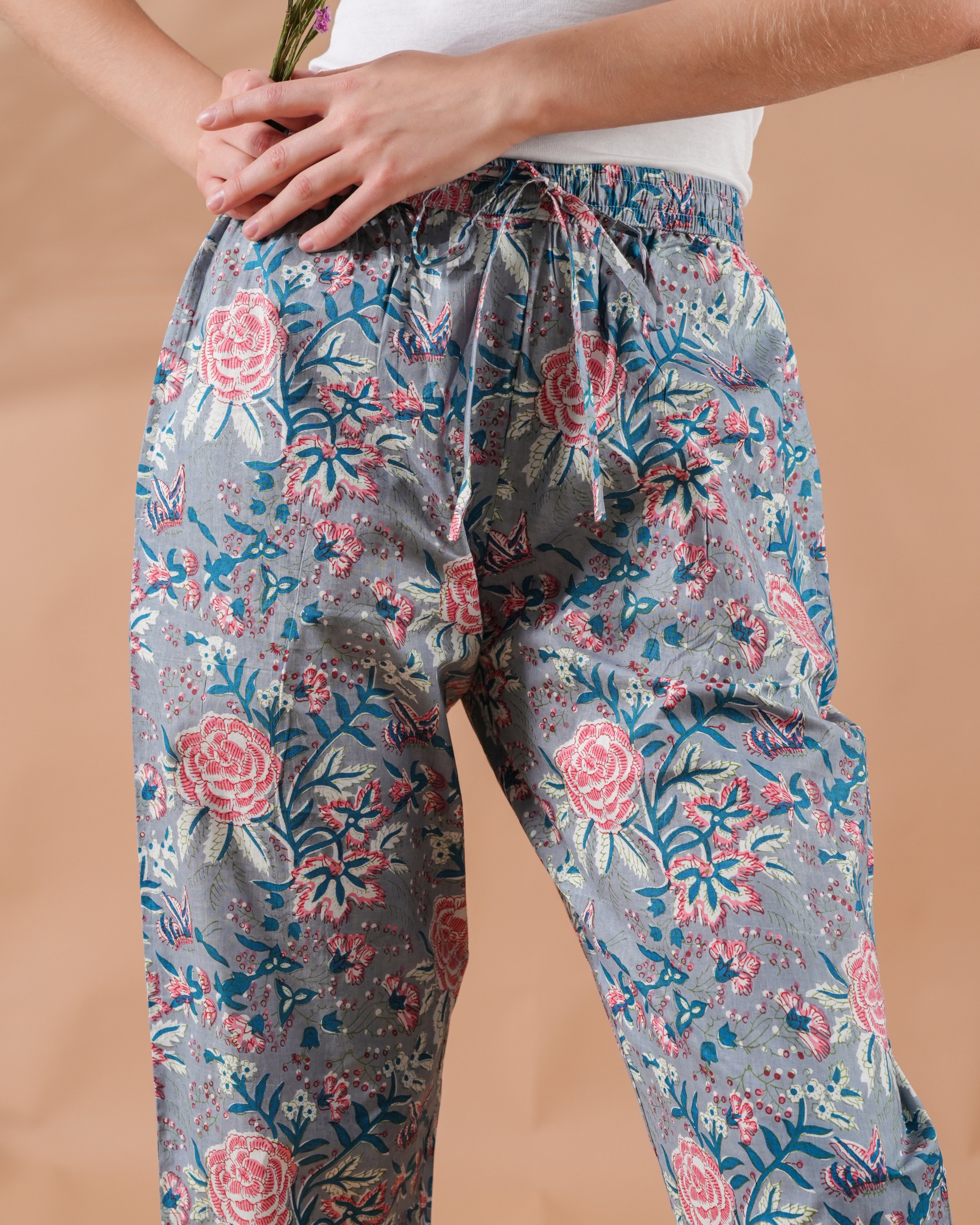 Trendy gray floral pajama pants with pockets and elastic waist, handmade from all-cotton with pink flower details—ideal for self-care, travel, or bridal shower gifts.