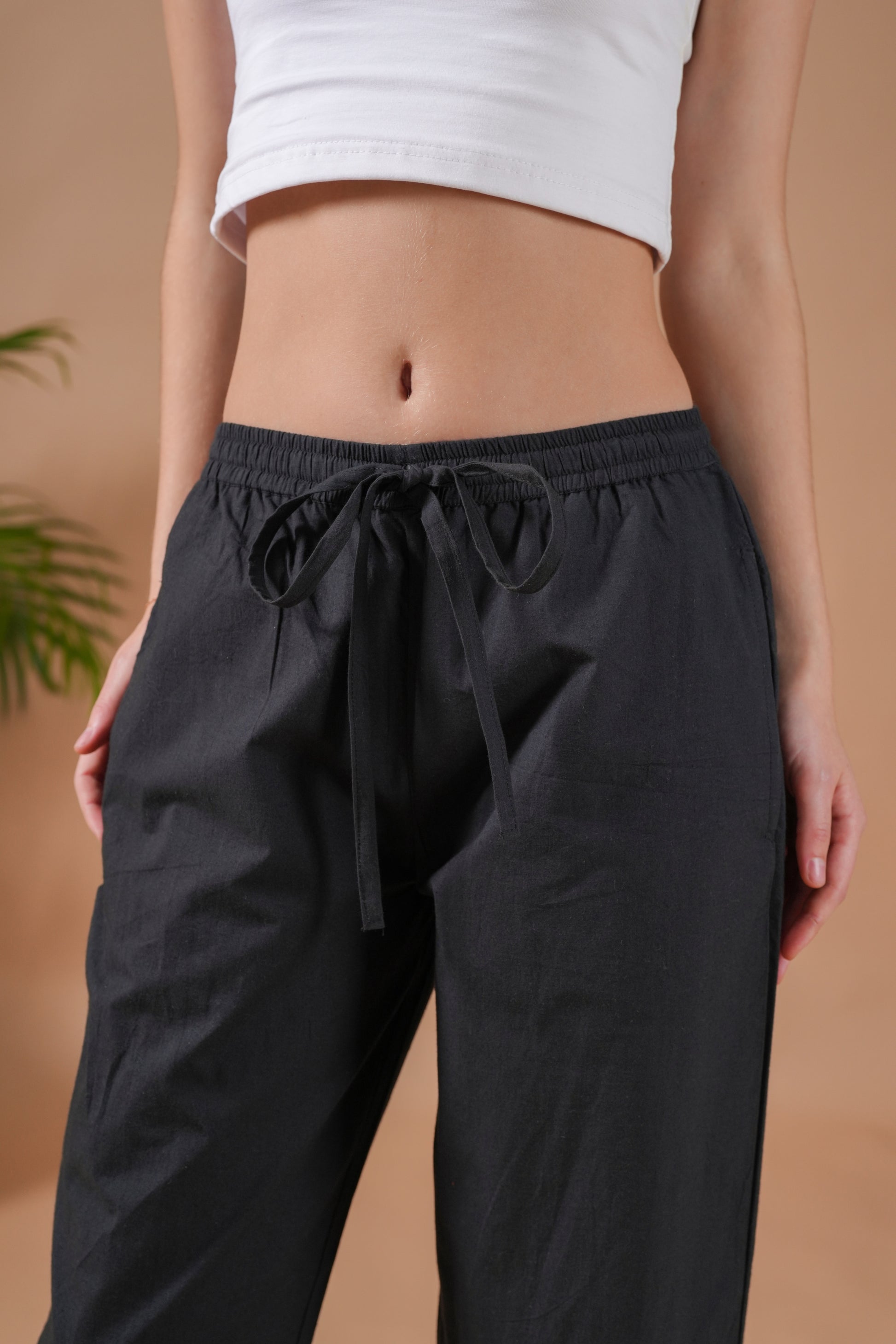 Minimalist black cotton lounge & sleepwear pants with a comfortable drawstring waistband and pockets—perfect for travel, yoga, or relaxing nights at home.