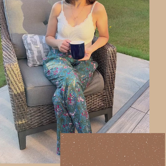 Comfortable women’s cotton pajama pants with a floral and butterfly design on a dark blue background. The pants have an elastic waistband, side pockets, and are perfect for lounging.