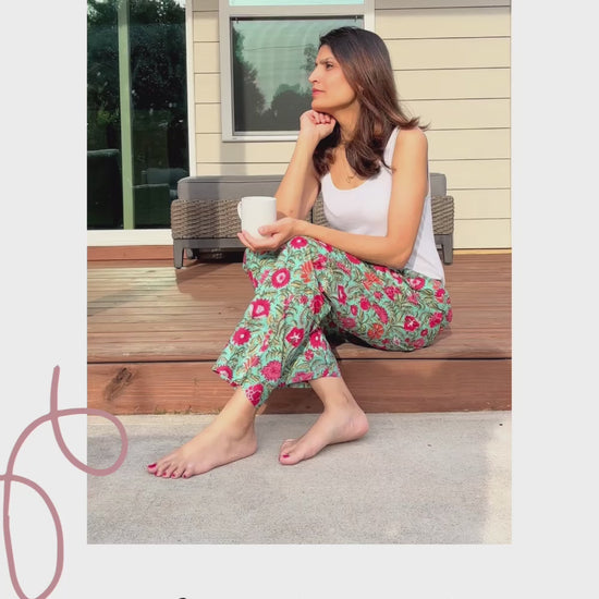 Soft and breathable 100% cotton pajama pants for women, with pink and white flowers on a light green background, elastic waist, and practical pockets