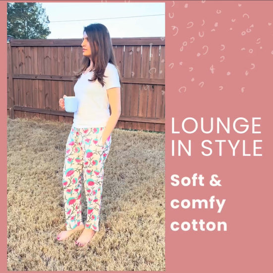 Relaxed-fit floral lounge pants for women, perfect for lounging, made from 100% cotton with a drawstring waist and vibrant pink flowers.