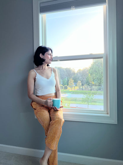 Comfortable women's pajama/lounge pants with a cheerful yellow and red striped pattern, an elastic waist, and pockets