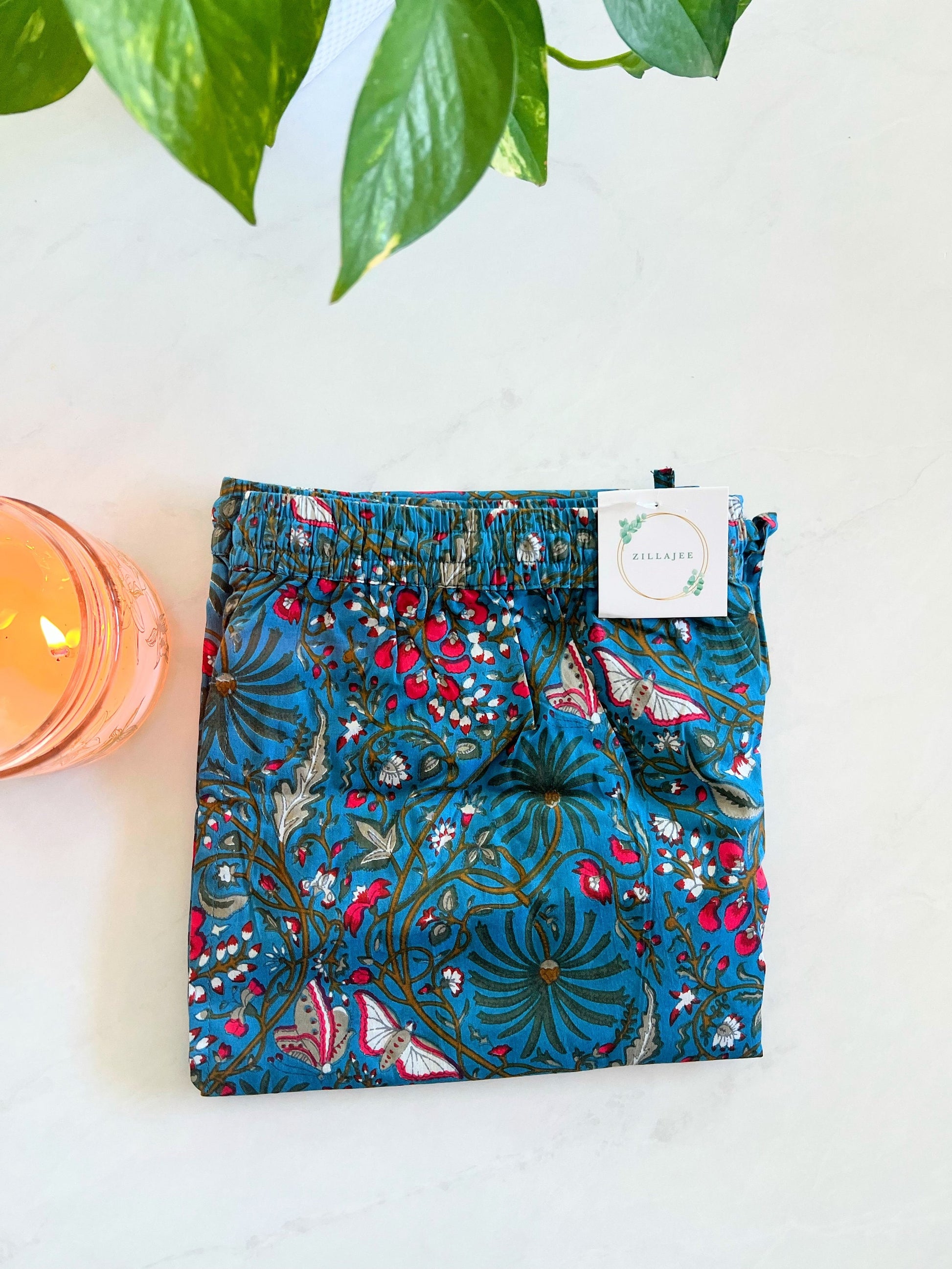 Dark blue cotton pajama pants for women with a floral and butterfly print. Featuring an elastic waistband and pockets, these pants are ideal for lounging and relaxation.